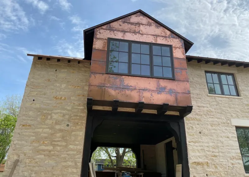 Copper metal panel facade on a stone building for Skylight Installation in Red Oak
